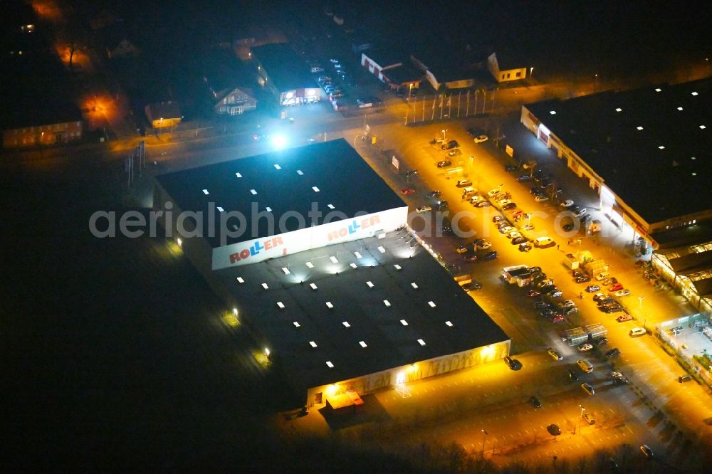 Fürstenwalde/Spree at night from the bird perspective: Night lighting Building of the store - furniture market Roller Moebel - Fuerstenwalde on Alte Langewahler Chaussee in Fuerstenwalde/Spree in the state Brandenburg, Germany