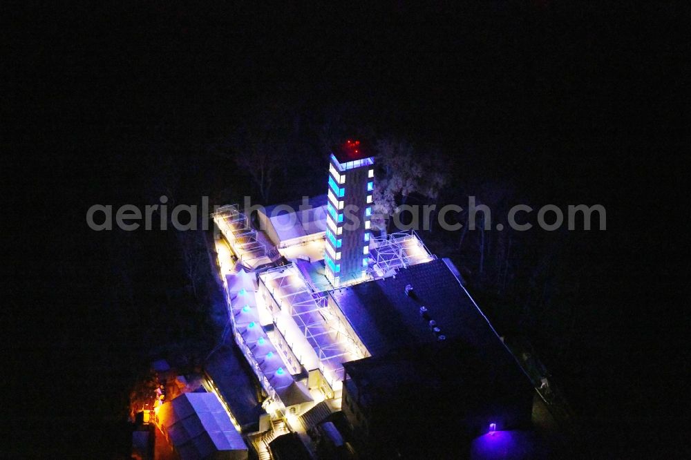 Berlin at night from the bird perspective: Night lighting Site of the tower- building ensemble of Mueggelturm in the forest Mueggelbergen Koepenick in Berlin