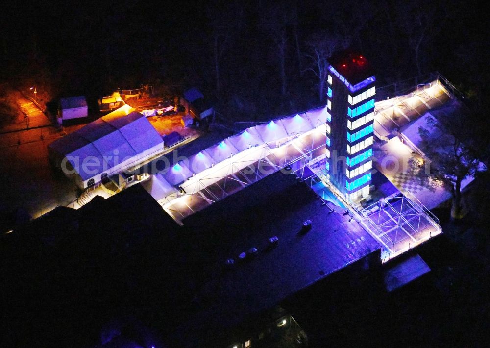 Aerial image at night Berlin - Night lighting Site of the tower- building ensemble of Mueggelturm in the forest Mueggelbergen Koepenick in Berlin