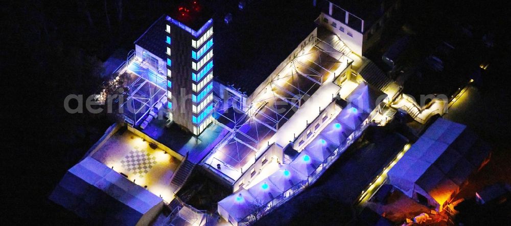 Aerial image at night Berlin - Night lighting Site of the tower- building ensemble of Mueggelturm in the forest Mueggelbergen Koepenick in Berlin