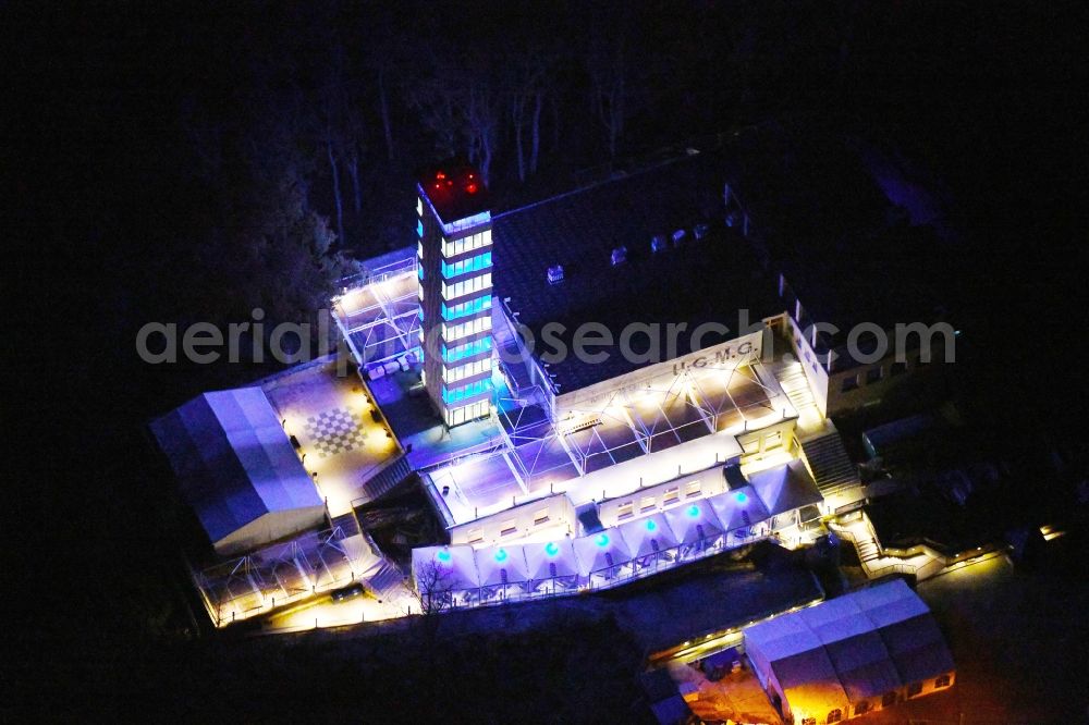 Aerial image at night Berlin - Night lighting Site of the tower- building ensemble of Mueggelturm in the forest Mueggelbergen Koepenick in Berlin