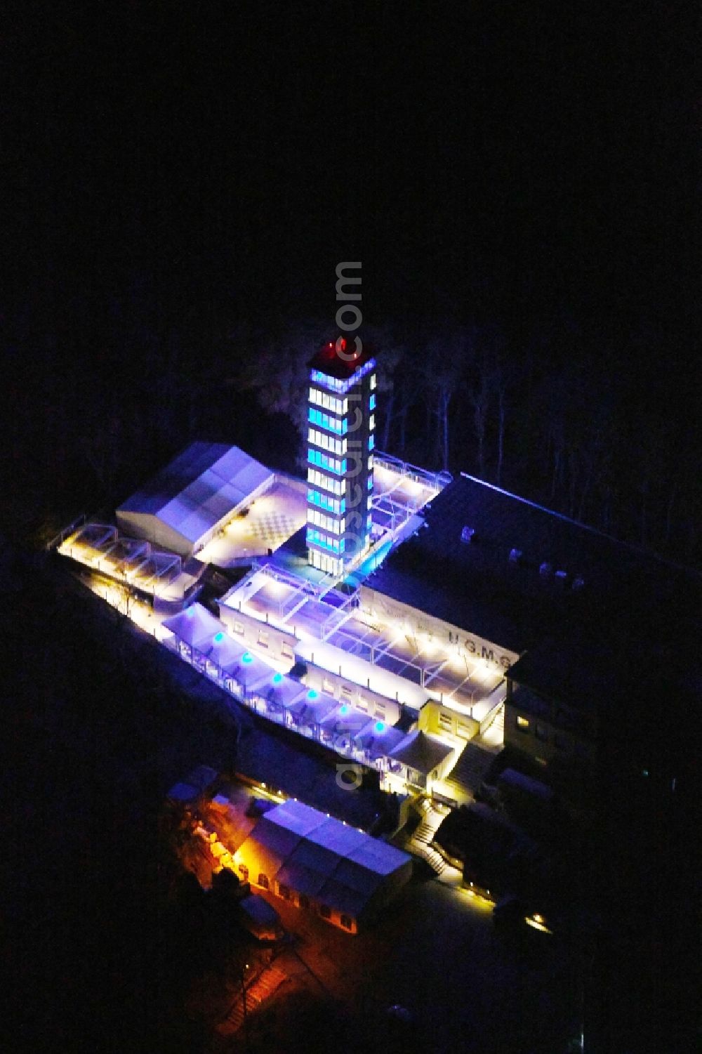 Aerial image at night Berlin - Night lighting Site of the tower- building ensemble of Mueggelturm in the forest Mueggelbergen Koepenick in Berlin