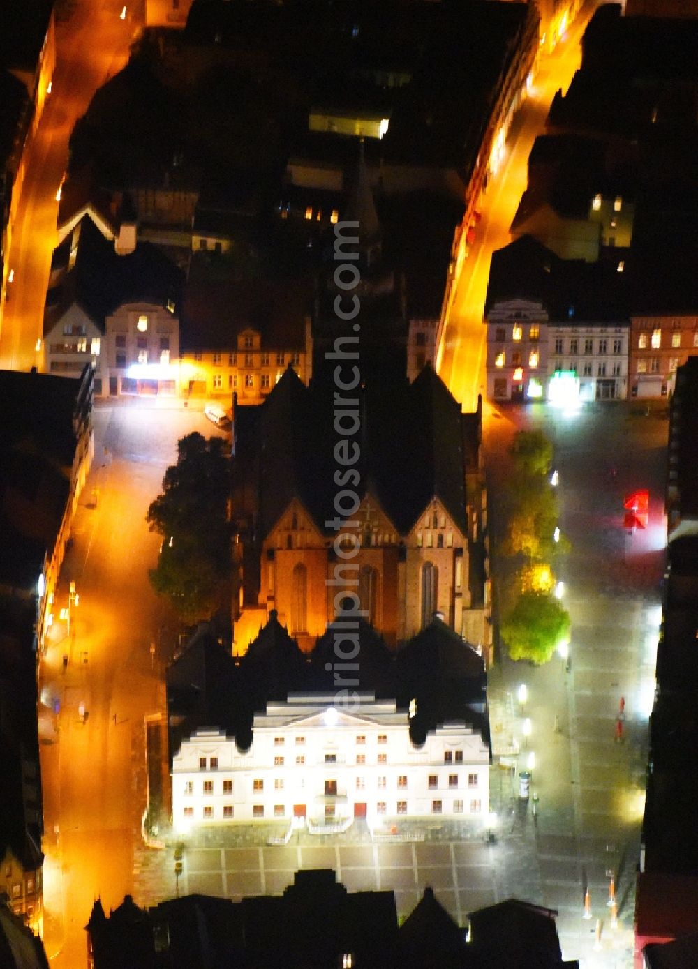 Aerial image at night Güstrow - Night lighting Town Hall building of the City Council at the market downtown in Guestrow in the state Mecklenburg - Western Pomerania, Germany