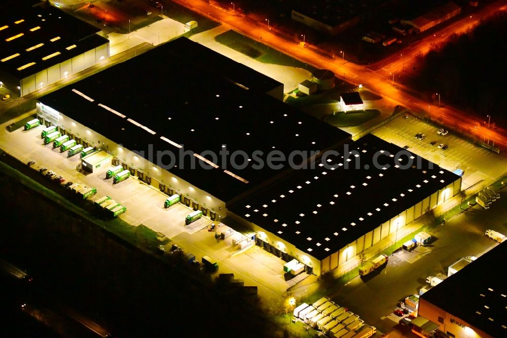 Wustermark at night from the bird perspective: Night lighting building complex and grounds of the logistics center of Brueof Schlau GmbH & Co. KG in Wustermark in the state Brandenburg, Germany