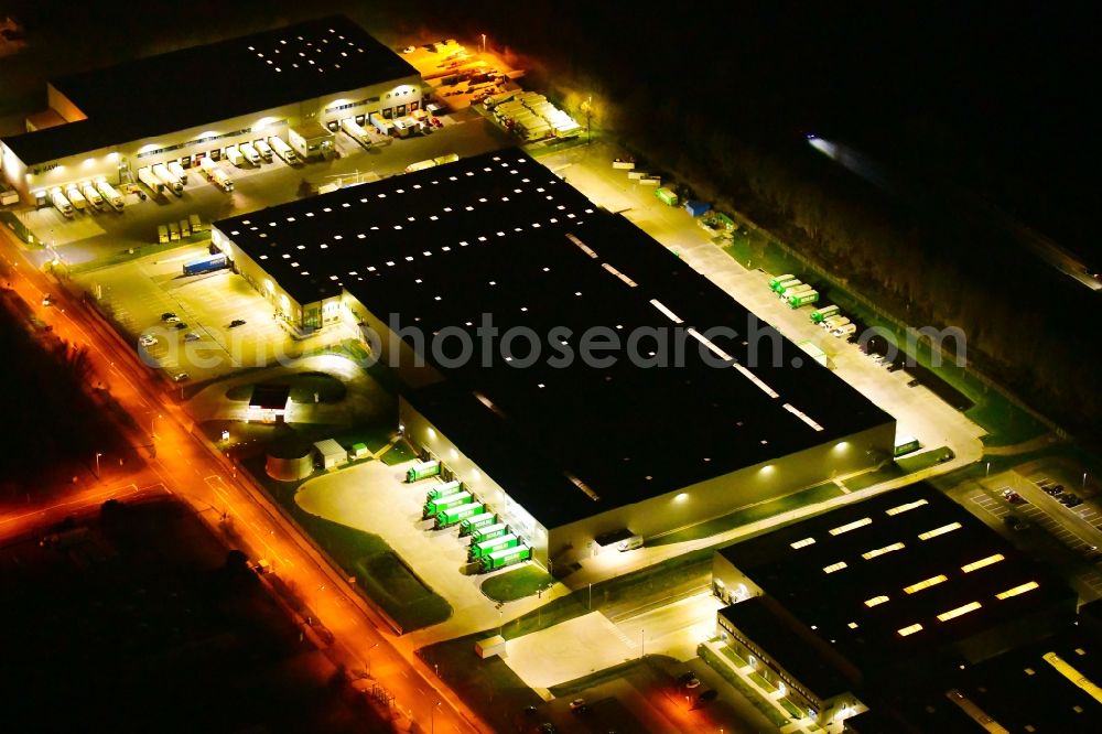 Aerial photograph at night Wustermark - Night lighting building complex and grounds of the logistics center of Brueof Schlau GmbH & Co. KG in Wustermark in the state Brandenburg, Germany