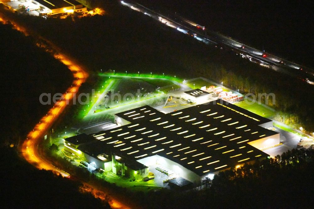 Aerial image at night Ludwigsfelde - Night lighting Building complex and grounds of the logistics center of Coca-Cola Erfrischungsgetraenke AG on Parkallee in Ludwigsfelde in the state Brandenburg, Germany