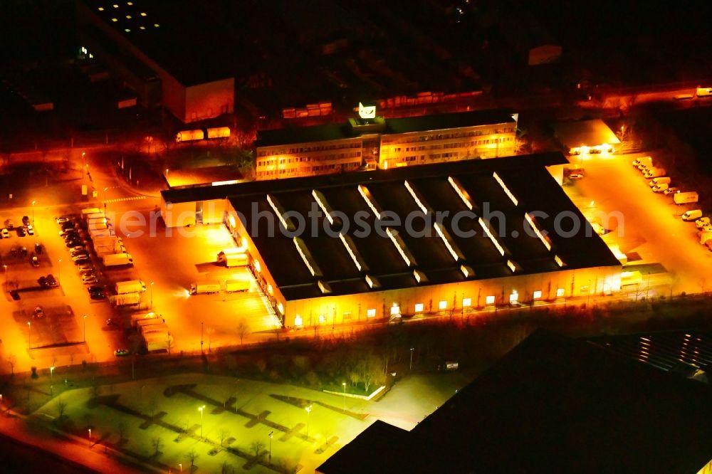 Hennigsdorf at night from the bird perspective: Night lighting building complex and grounds of the logistics center Deutsche Post Briefzentrum Henningsdorf on Walter-Kleinow-Ring in Hennigsdorf in the state Brandenburg, Germany