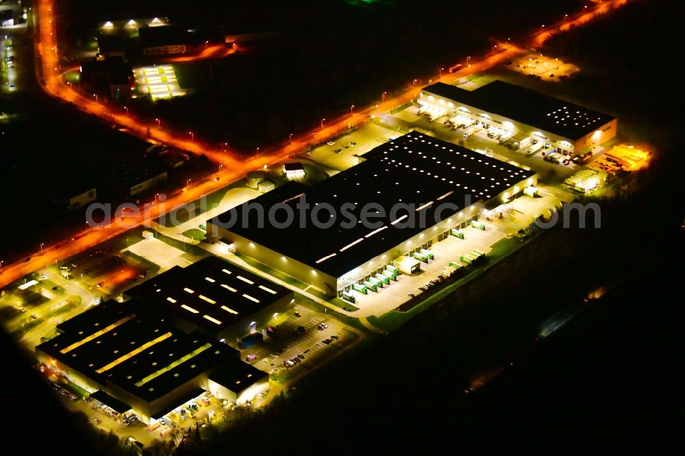 Aerial image at night Wustermark - Night lighting building complex and grounds of the logistics center of J&S GmbH Automotive Technology and of Brueof Schlau GmbH & Co. KG in Wustermark in the state Brandenburg, Germany