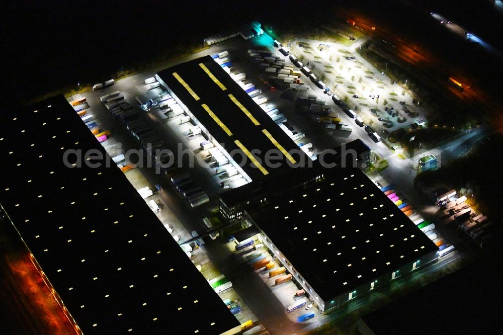 Hamburg at night from the bird perspective: Night lighting building complex and grounds of the logistics center of Kuehne + Nagel KG Beim Schroeofschen Hof in Hamburg, Germany