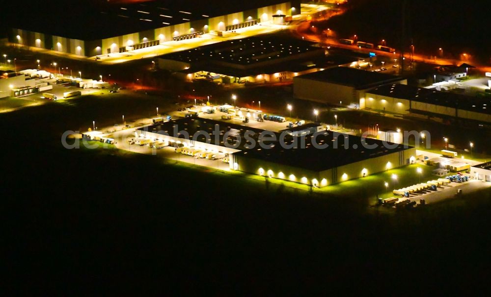 Aerial photograph at night Wustermark - Night lighting building complex and grounds of the logistics center of Kraftverkehr Nagel SE & Co. KG on Kurt-Nagel-Strasse in Wustermark in the state Brandenburg, Germany