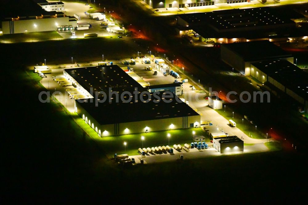 Aerial image at night Wustermark - Night lighting building complex and grounds of the logistics center of Kraftverkehr Nagel SE & Co. KG on Kurt-Nagel-Strasse in Wustermark in the state Brandenburg, Germany