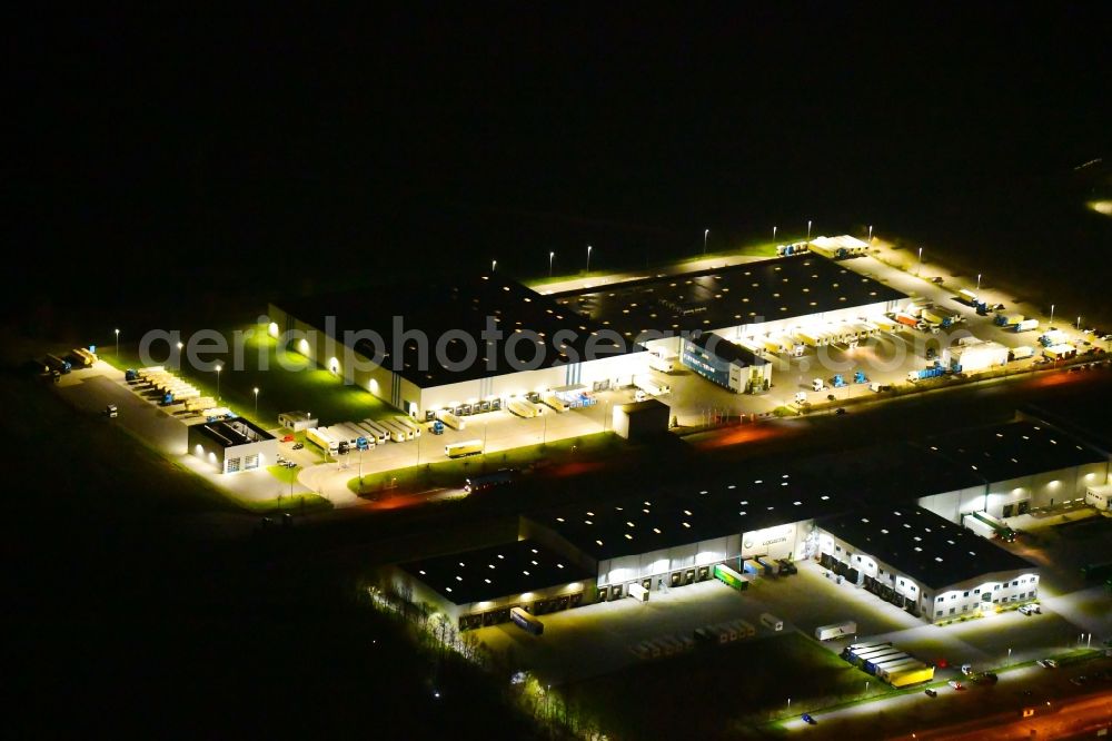 Wustermark at night from above - Night lighting building complex and grounds of the logistics center of Kraftverkehr Nagel SE & Co. KG on Kurt-Nagel-Strasse in Wustermark in the state Brandenburg, Germany