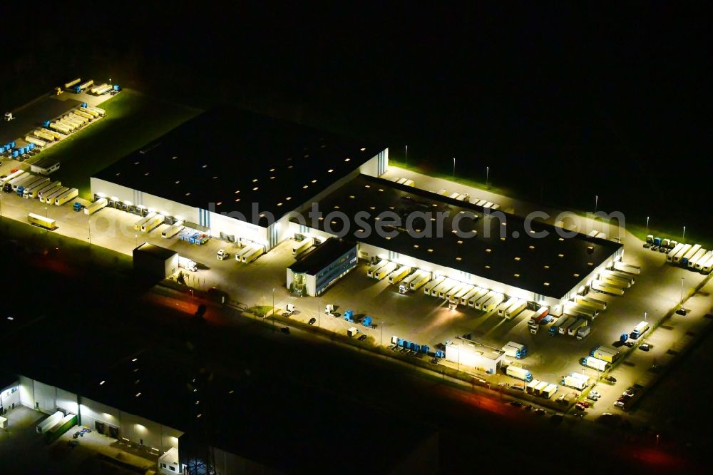 Aerial image at night Wustermark - Night lighting building complex and grounds of the logistics center of Kraftverkehr Nagel SE & Co. KG on Kurt-Nagel-Strasse in Wustermark in the state Brandenburg, Germany