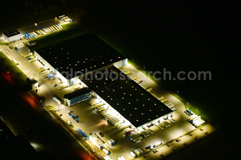 Wustermark at night from above - Night lighting building complex and grounds of the logistics center of Kraftverkehr Nagel SE & Co. KG on Kurt-Nagel-Strasse in Wustermark in the state Brandenburg, Germany