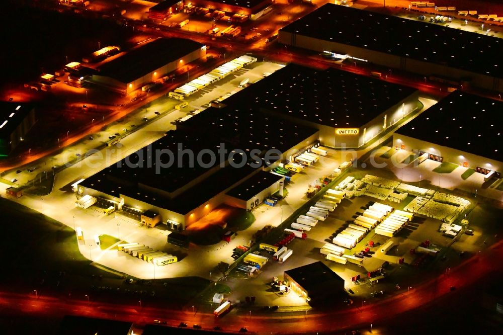 Aerial image at night Wustermark - Night lighting building complex and grounds of the logistics center of NETTO ApS & Co. KG in Wustermark in the state Brandenburg, Germany