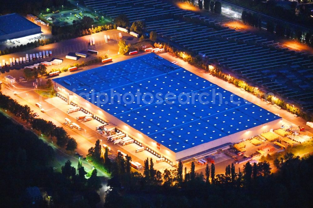 Berlin at night from the bird perspective: Night lighting building complex and grounds of the logistics center of Rewe Logistik GmbH on Altes Gaswerk Mariendorf in Berlin, Germany