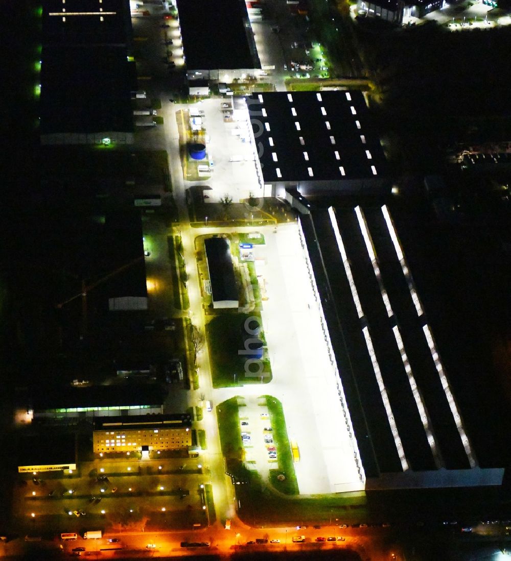 Aerial photograph at night Hoppegarten - Night lighting Building complex and grounds of the logistics center of Rhenus Home Delivery GmbH in of Industriestrasse in Hoppegarten in the state Brandenburg, Germany