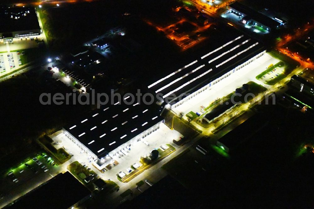 Aerial photograph at night Hoppegarten - Night lighting Building complex and grounds of the logistics center of Rhenus Home Delivery GmbH in of Industriestrasse in Hoppegarten in the state Brandenburg, Germany