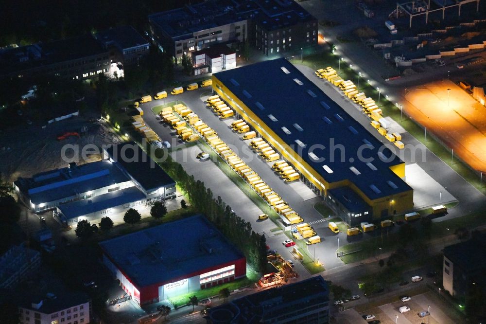 Berlin at night from above - Night lighting building complex and distribution center on the site Deutsche Post - DHL Mech.ZB BRITZ on Gradestrasse in the district Bezirk Neukoelln in Berlin, Germany