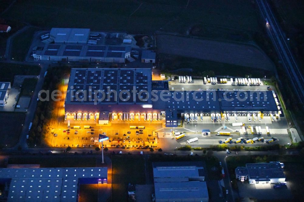 Aerial photograph at night Dissen am Teutoburger Wald - Night lighting Building complex and distribution center on the site of Dachser SE Food Logistics on Konpweg in Dissen am Teutoburger Wald in the state Lower Saxony, Germany