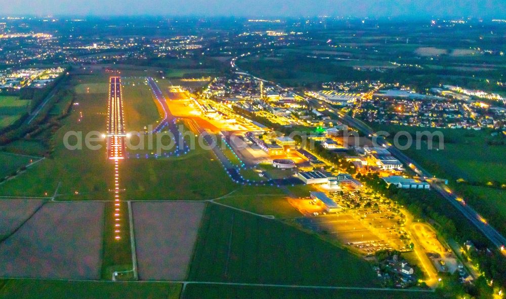 Dortmund at night from above - Night lighting runway with hangar taxiways and terminals on the grounds of the airport in Dortmund at Ruhrgebiet in the state North Rhine-Westphalia, Germany