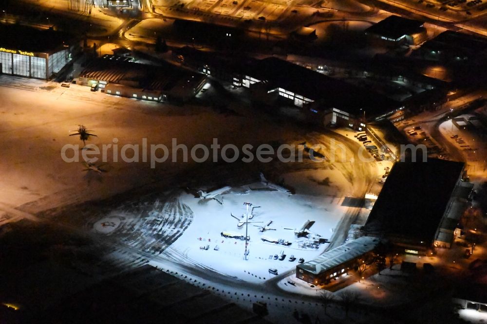 Schönefeld at night from the bird perspective: Night view wintry snowy hangar taxiways and terminals on the grounds of the airport GAT in the district Schoenefeld in Schoenefeld in the state Brandenburg