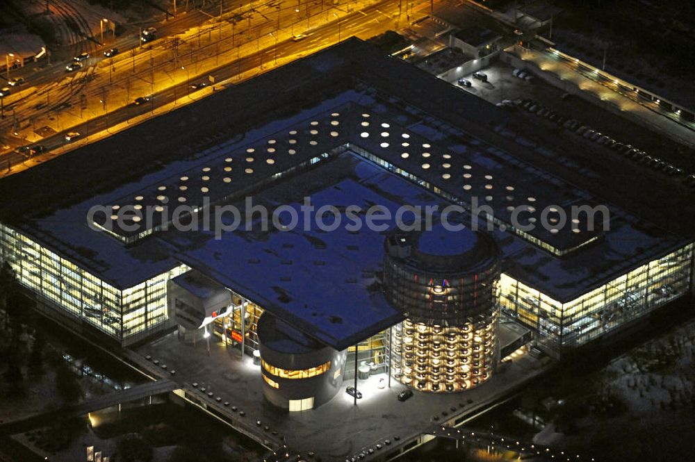 Dresden at night from above - Nachtaufnahme der winterlich mit Schnee bedeckten Gläsernen Manufaktur in der Innenstadt. Die Gläserne Manufaktur ist eine Autofabrik des Volkswagen-Konzerns und entstand auf dem Gelände des ehemaligen Messeplatzes am Straßburger Platz. Das Gebäude verfügt neben den Fertigungsanlagen auch über Gastronomie- und Kultureinrichtungen. Night shot of the wintry snow-covered Transparent Factory in the city center.