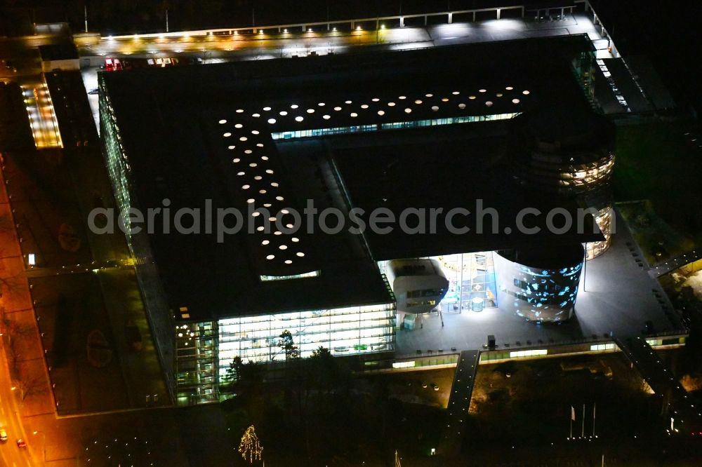 Aerial photograph at night Dresden - Night lighting VW transparent factory in Dresden in Saxony. The transparent factory is a Dresden automobile factory of Volkswagen AG, which is operated by the Volkswagen Sachsen GmbH