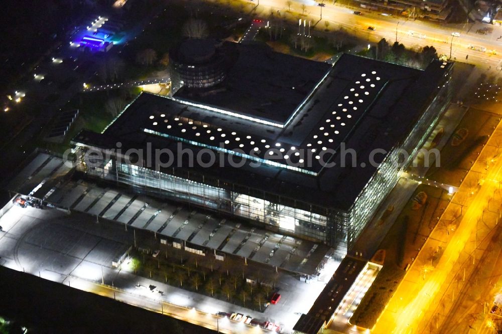 Aerial image at night Dresden - Night lighting VW transparent factory in Dresden in Saxony. The transparent factory is a Dresden automobile factory of Volkswagen AG, which is operated by the Volkswagen Sachsen GmbH