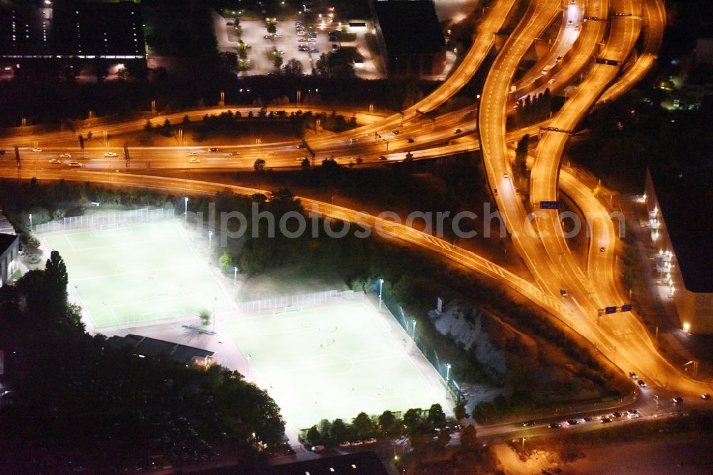 Aerial photograph at night Berlin - Night view green colored tennis sports complex aloung highway A100 destrict Neukoelln in Berlin