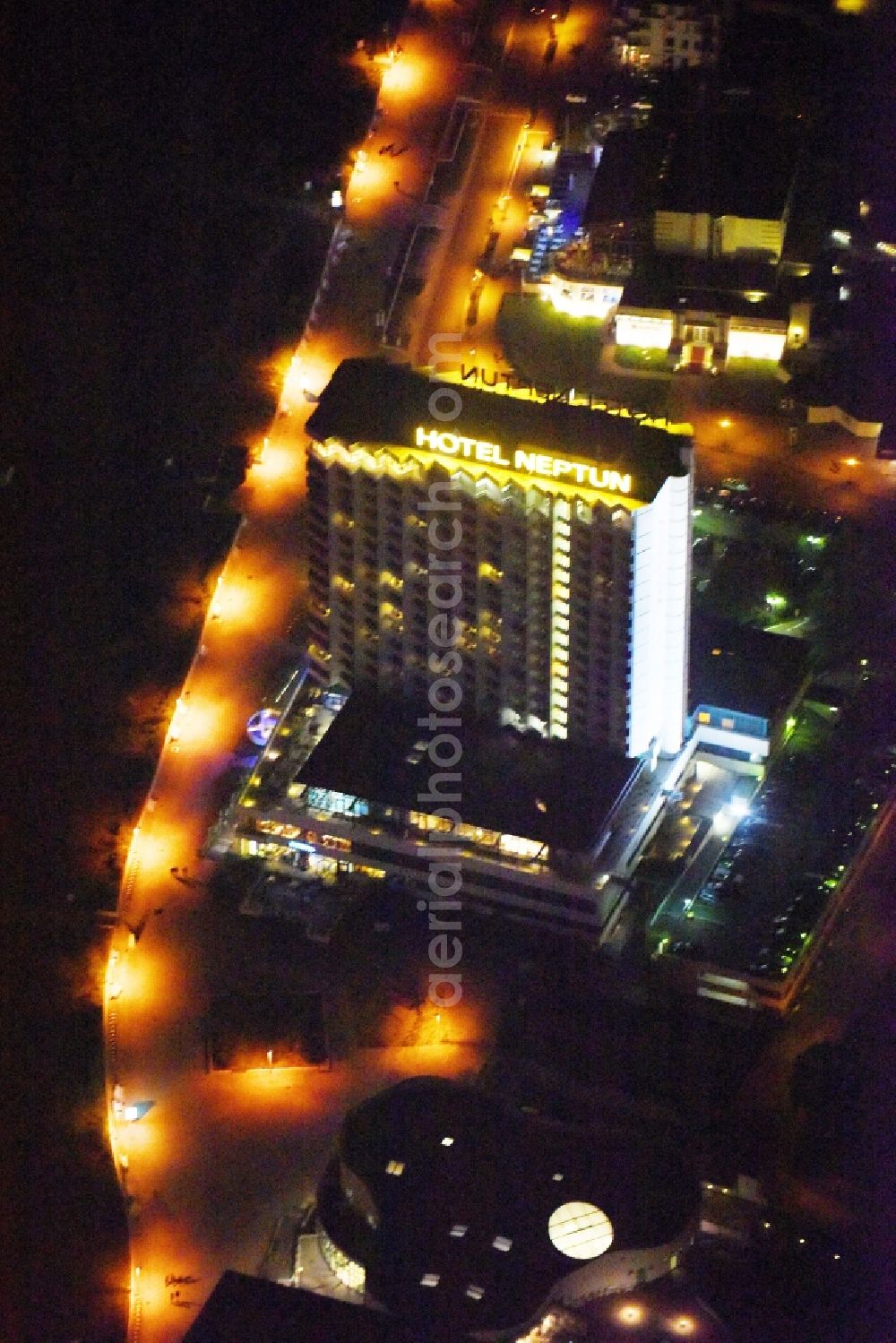 Aerial image at night Rostock - Night lighting High-rise building of the hotel complex Hotel NEPTUN on Seestrasse in Rostock in the state Mecklenburg - Western Pomerania, Germany