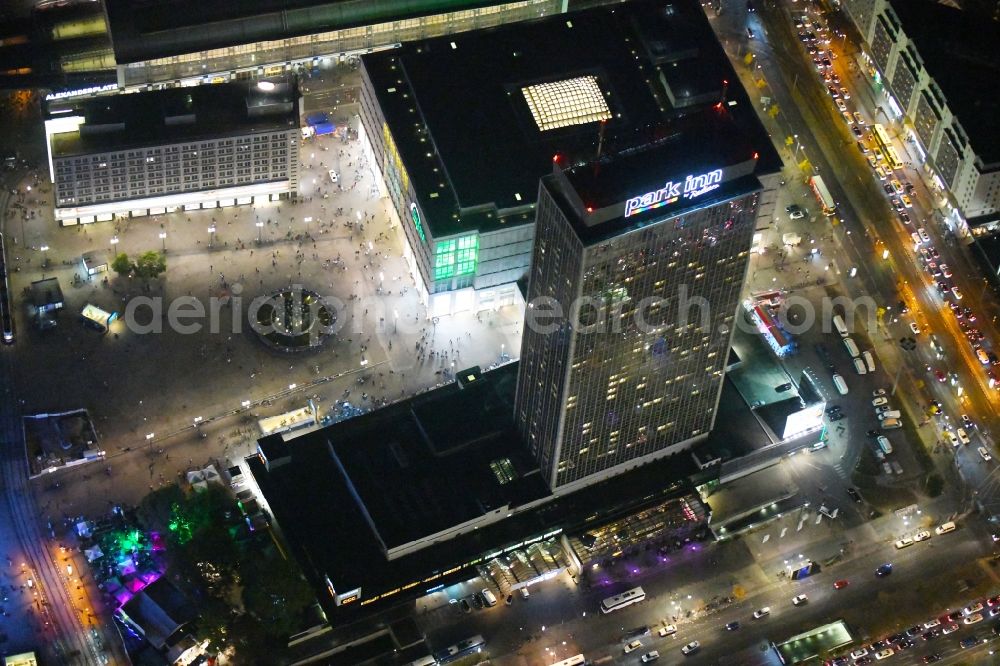 Aerial photograph at night Berlin - Night lighting High-rise building of the hotel complex Park Inn by Radisson Berlin Alexanderplatz in the district Mitte in Berlin, Germany