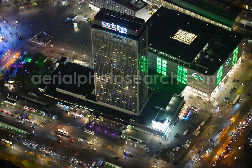 Aerial image at night Berlin - Night lighting High-rise building of the hotel complex Park Inn by Radisson Berlin Alexanderplatz in the district Mitte in Berlin, Germany