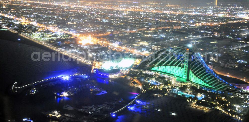 Dubai at night from the bird perspective: Blick auf das Jumeirah Hotel und den Pavillon Marina & Sports Club in Dubai bei Nacht. Im Hintergrund die Stadt Dubai als Nachtaufnahme. View of the Jumeirah and the Pavilion Marina & Sports Club in Dubai at night. In the background the city Dubai as night photograph.