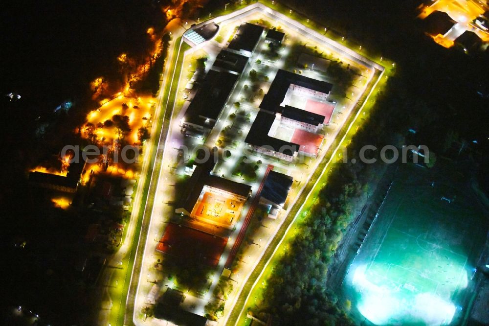 Aerial image at night Wriezen - Night lighting prison grounds and high security fence Prison Justizvollzugsanstalt Nord-Brandenburg Teilanstalt Wriezen on street Schulzendorfer Strasse in the district Luedersdorf in Wriezen in the state Brandenburg, Germany