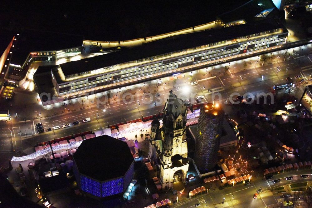 Aerial image at night Berlin - Night view of the Protestant Kaiser William Memorial Church, commonly short memorial church with cristmas market on place Breitscheidplatz between the Kurfuerstendamm, the Tauentzienstrasse and the Budapest street in Berlin's Charlottenburg district