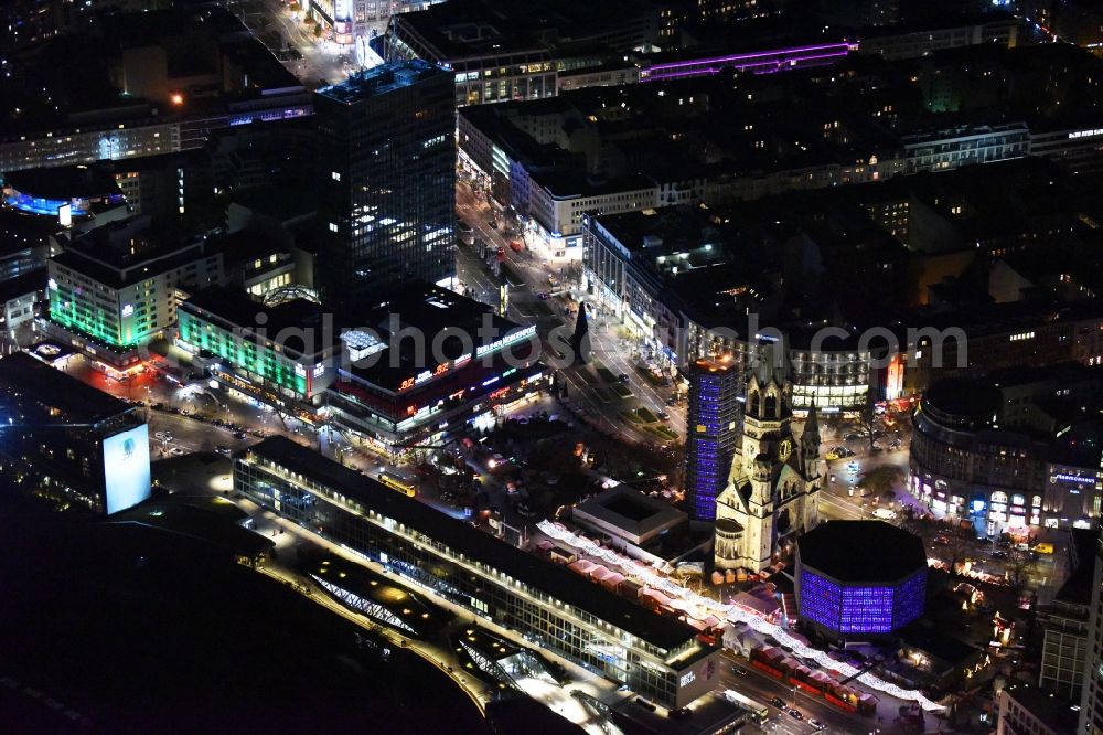 Berlin at night from the bird perspective: Night view of the Protestant Kaiser William Memorial Church, commonly short memorial church with cristmas market on place Breitscheidplatz between the Kurfuerstendamm, the Tauentzienstrasse and the Budapest street in Berlin's Charlottenburg district