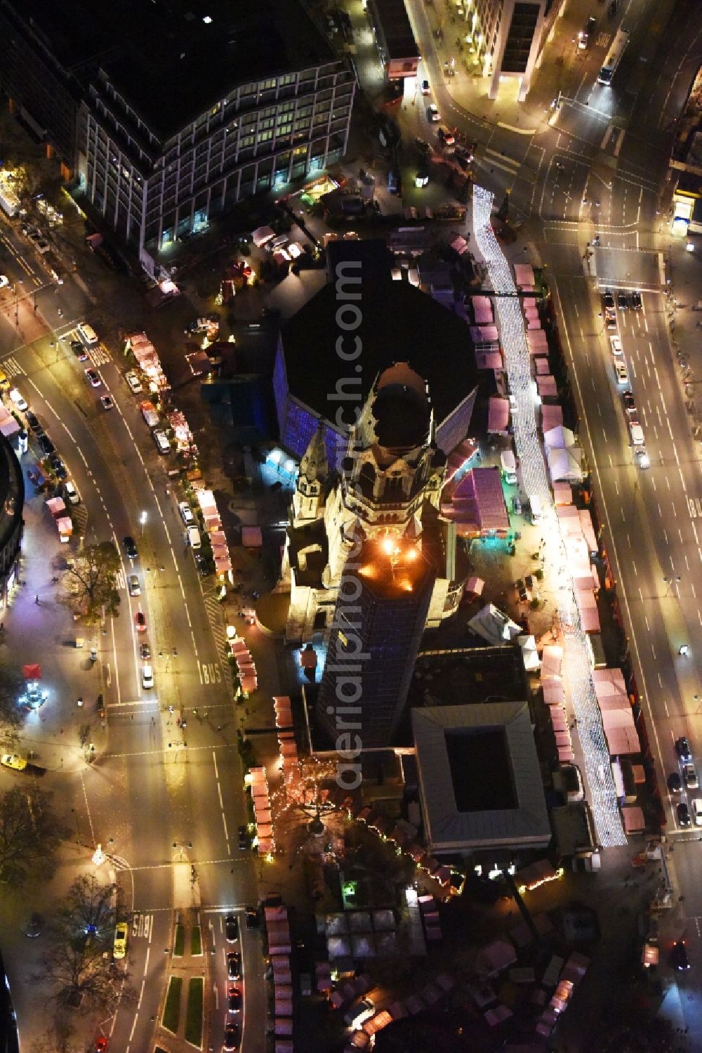 Aerial image at night Berlin - Night view of the Protestant Kaiser William Memorial Church, commonly short memorial church with cristmas market on place Breitscheidplatz between the Kurfuerstendamm, the Tauentzienstrasse and the Budapest street in Berlin's Charlottenburg district