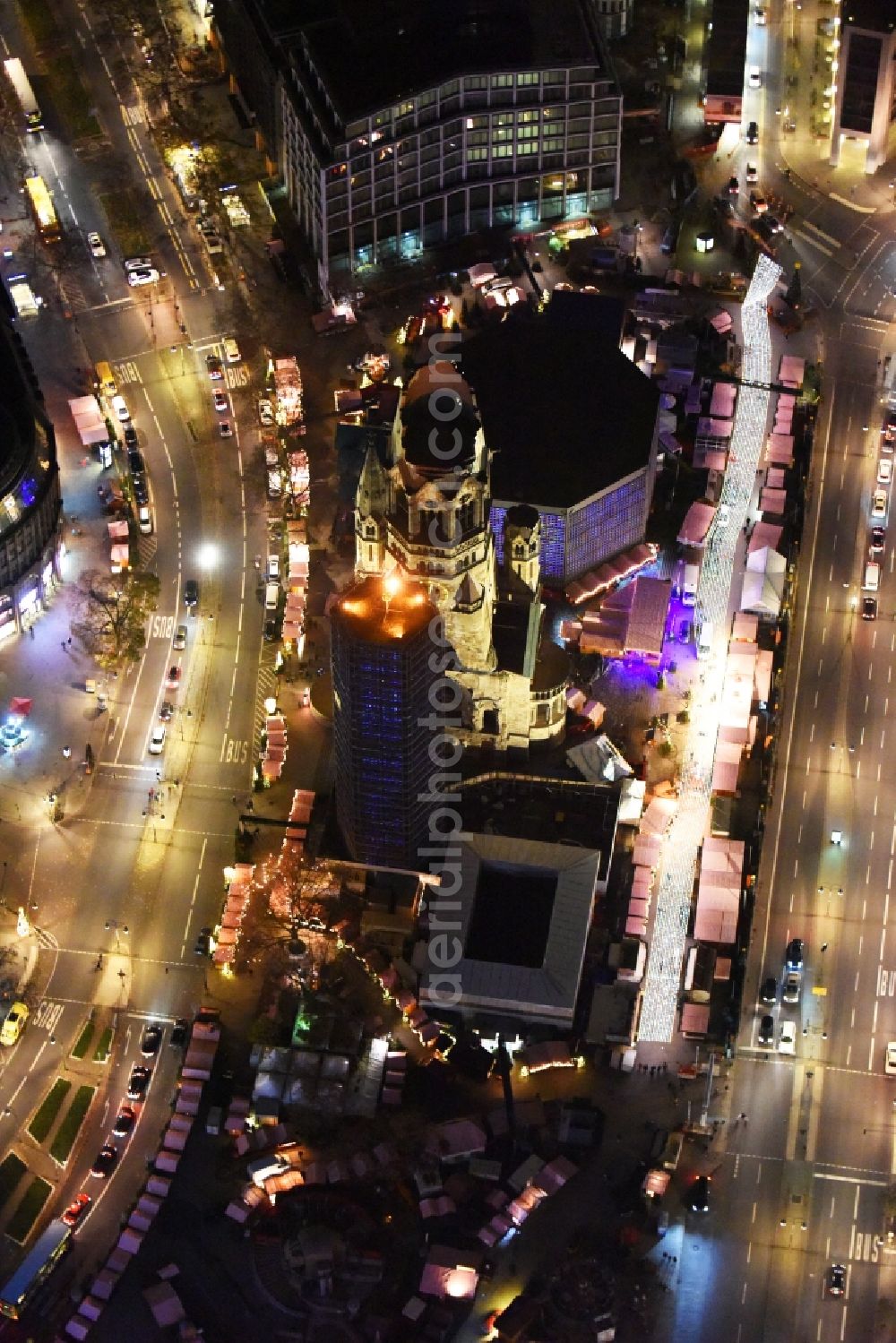 Berlin at night from above - Night view of the Protestant Kaiser William Memorial Church, commonly short memorial church with cristmas market on place Breitscheidplatz between the Kurfuerstendamm, the Tauentzienstrasse and the Budapest street in Berlin's Charlottenburg district