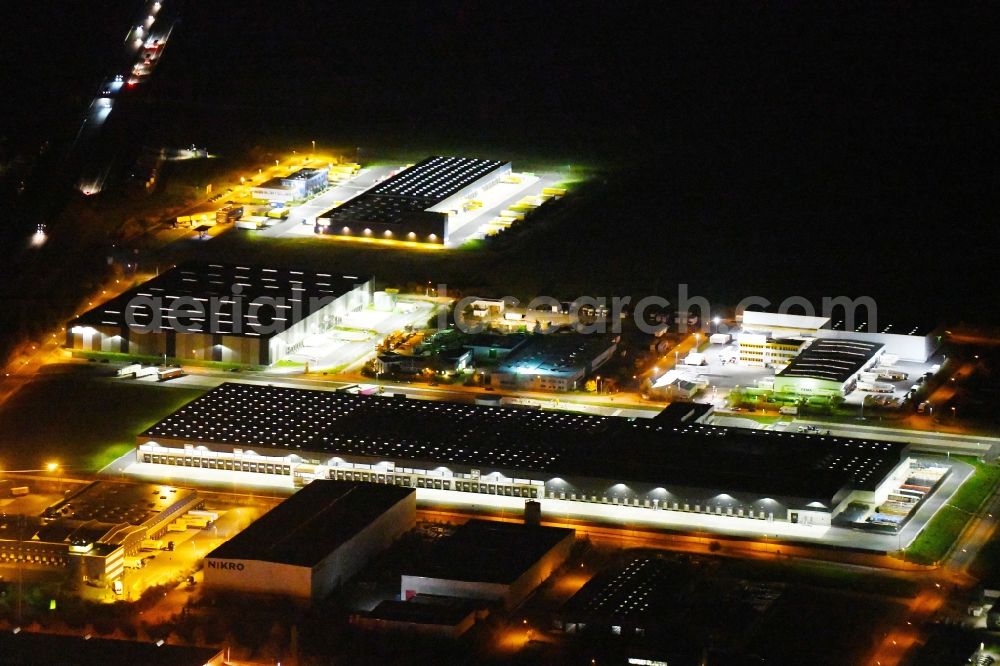 Radeburg at night from the bird perspective: Night lighting warehouses and forwarding building Lidl Zentrallager on Guerickestrasse in Radeburg in the state Saxony, Germany