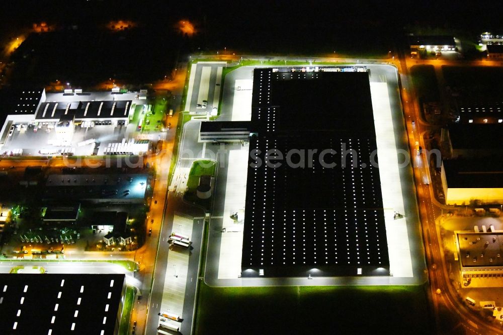 Radeburg at night from the bird perspective: Night lighting warehouses and forwarding building Lidl Zentrallager on Guerickestrasse in Radeburg in the state Saxony, Germany