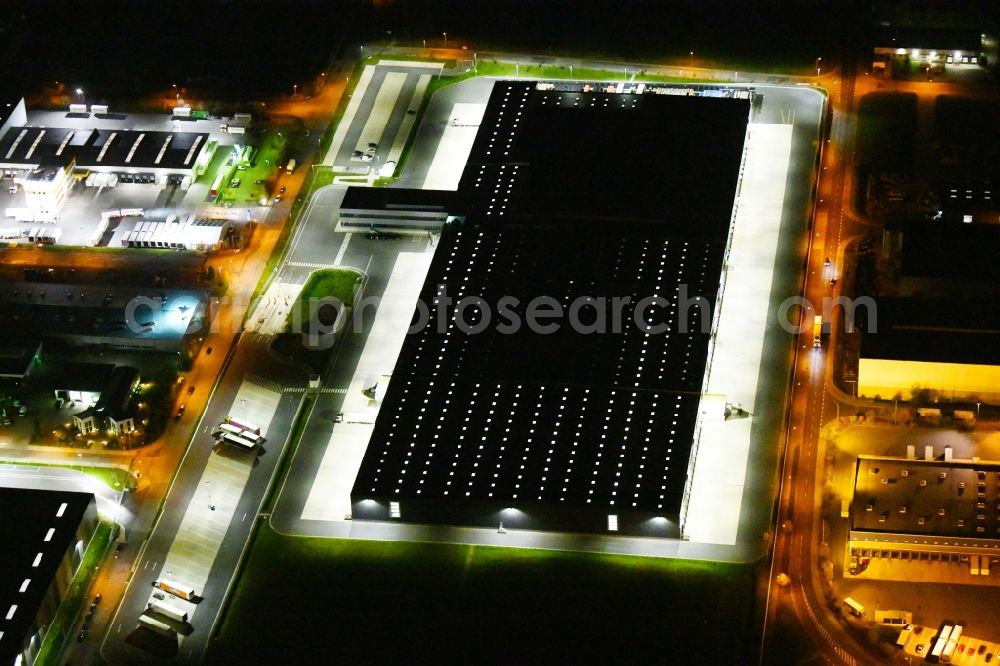 Aerial photograph at night Radeburg - Night lighting warehouses and forwarding building Lidl Zentrallager on Guerickestrasse in Radeburg in the state Saxony, Germany