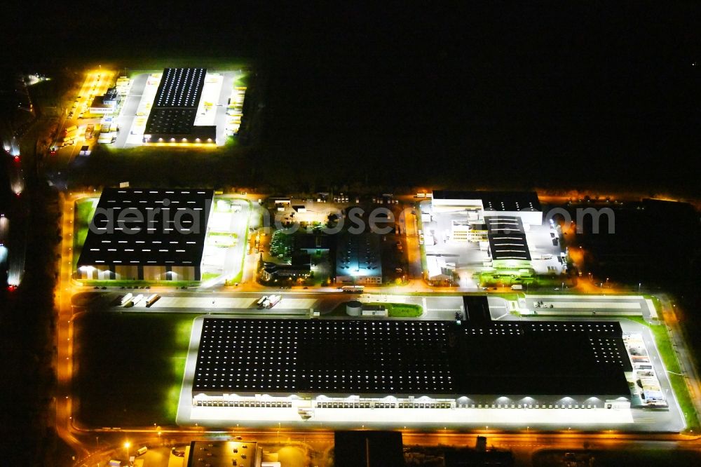 Aerial image at night Radeburg - Night lighting warehouses and forwarding building Lidl Zentrallager on Guerickestrasse in Radeburg in the state Saxony, Germany