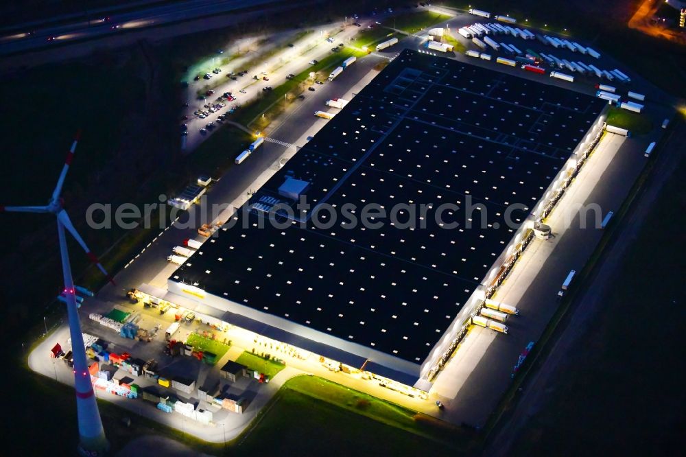 Aerial photograph at night Berlin - Night lighting warehouses and forwarding building Netto Grosslager in the district Buch in Berlin, Germany