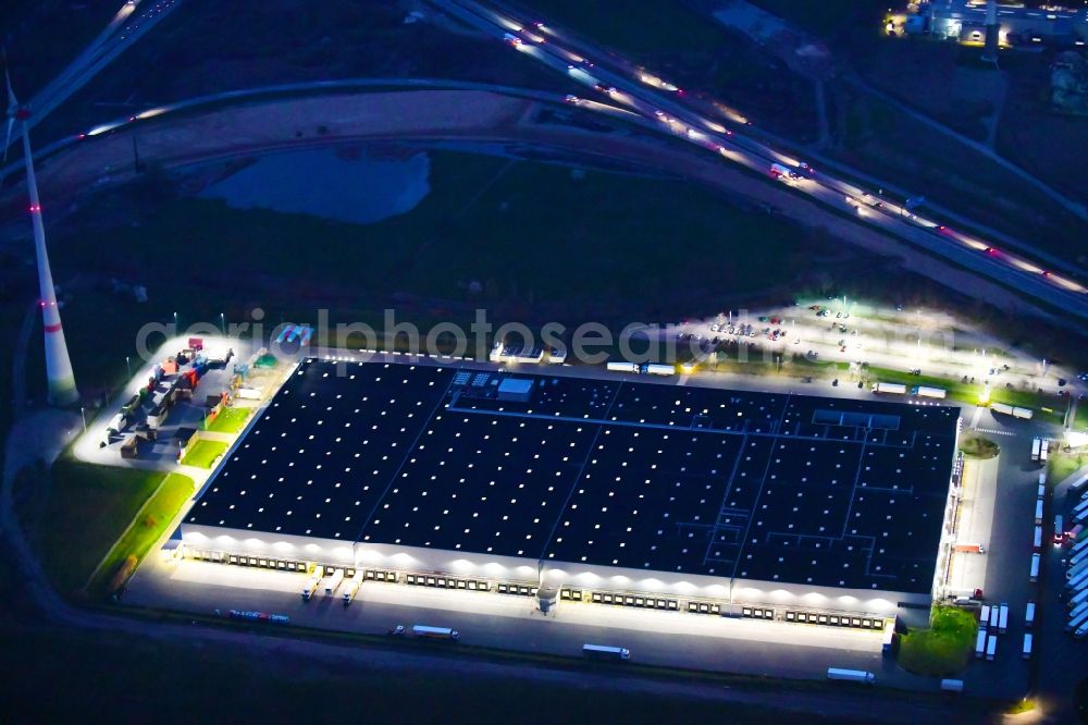 Aerial photograph at night Berlin - Night lighting warehouses and forwarding building Netto Grosslager in the district Buch in Berlin, Germany