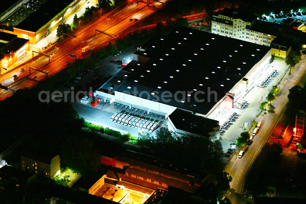 Aerial photograph at night Berlin - Night lighting warehouses and forwarding building REWE Food Fulfillment Center on street Teilestrasse in the district Tempelhof in Berlin, Germany