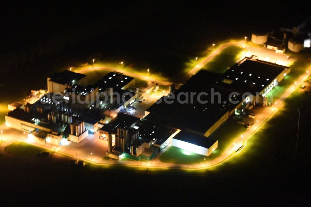 Klatzow at night from the bird perspective: Night lighting buildings and production halls on the food manufacturer's premises DMK Deutsches Milchkontor GmbH in Klatzow in the state Mecklenburg - Western Pomerania, Germany