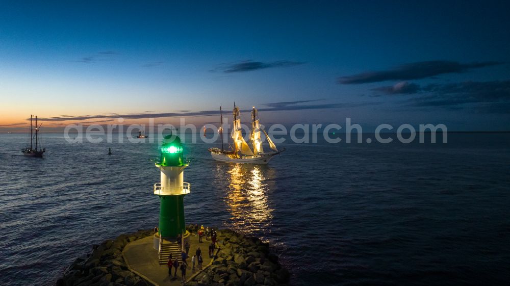 Rostock at night from above - Night lighting lighthouse as a historic seafaring character in the coastal area in Warnemuende in Rostock at the baltic sea coast in the state Mecklenburg - Western Pomerania, Germany