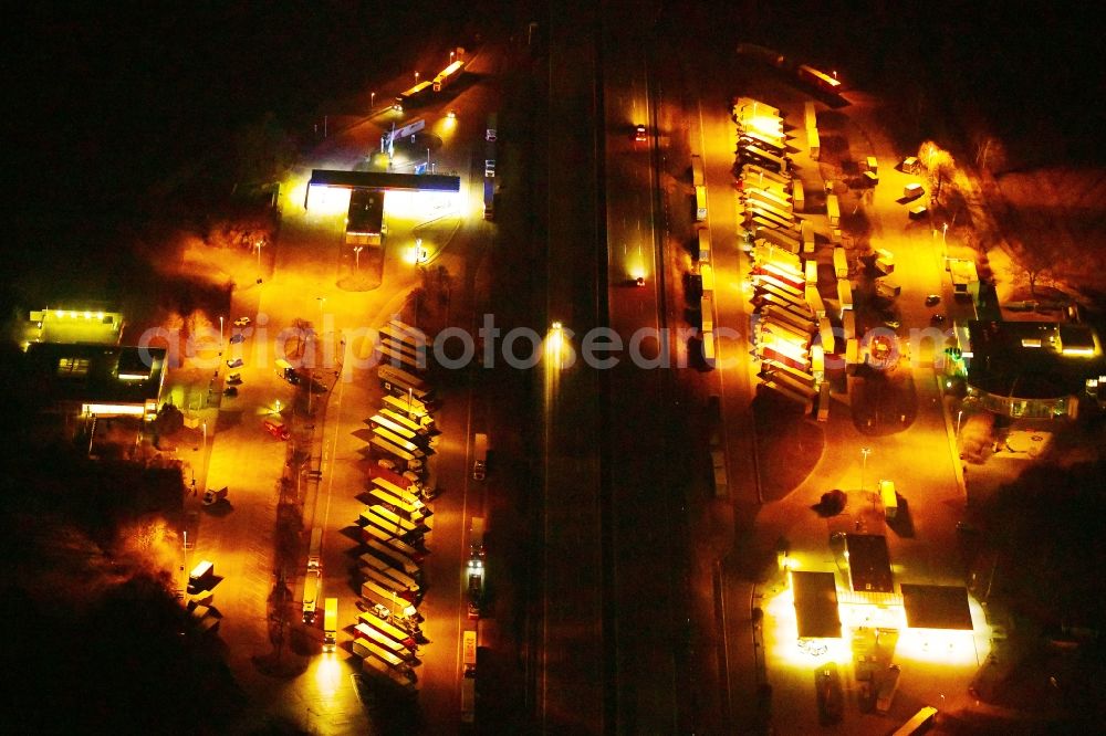 Knüllwald at night from the bird perspective: Night lighting lorries - parking spaces at the highway rest stop and parking of the BAB A 7 - Raststaette Hasselberg Ost in Knuellwald in the state Hesse, Germany