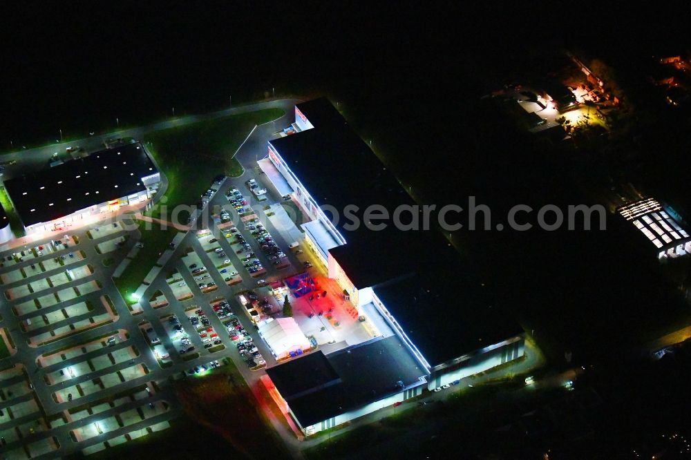 Aerial image at night Berlin - Night lighting site for the new building home-center of the Porta-Group at Pilgramer street in the district Mahlsdorf in Berlin